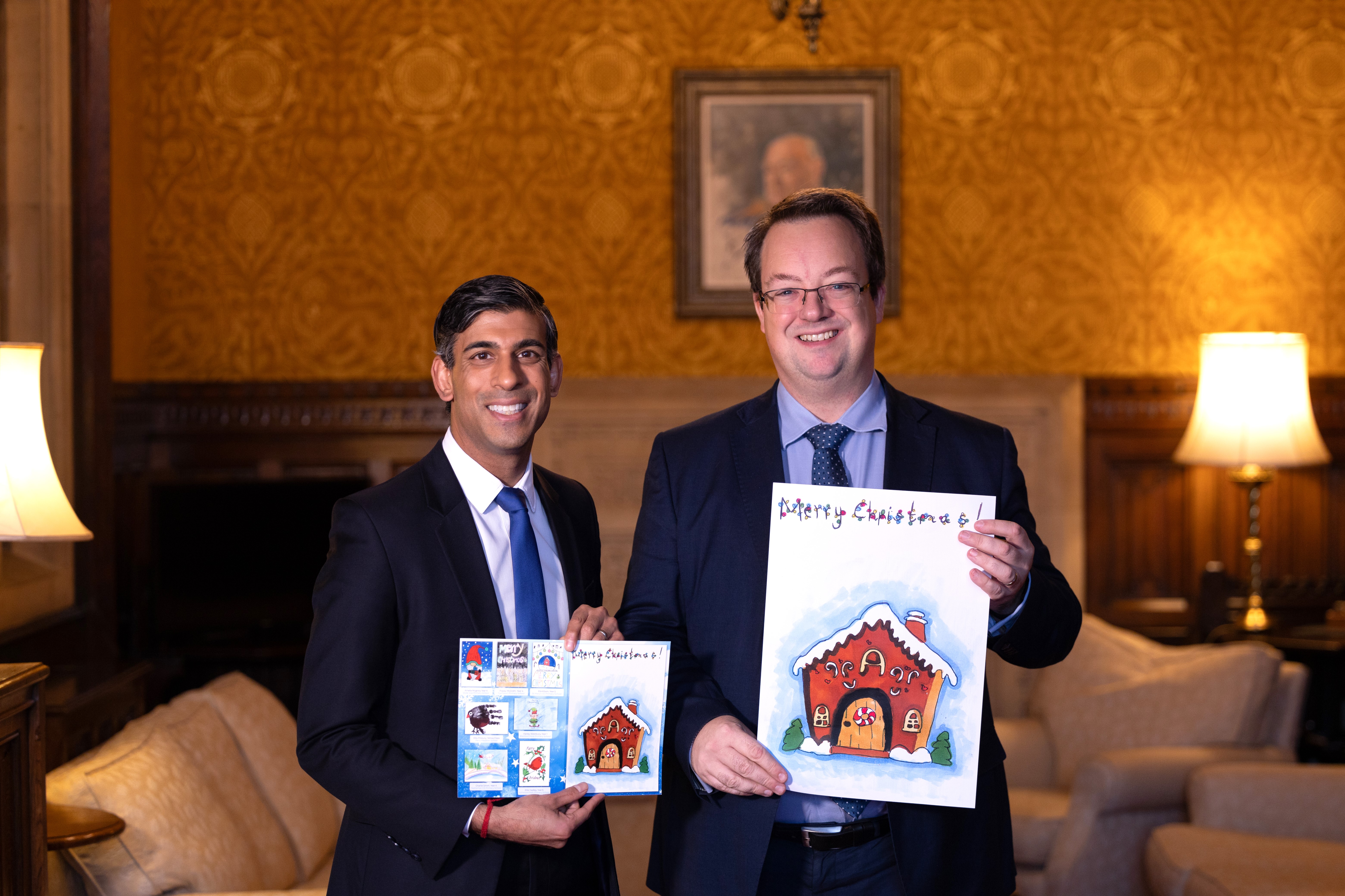Prime Minister Rishi Sunak with Mike and his 2023 Christmas card showing the winning and runner up designs